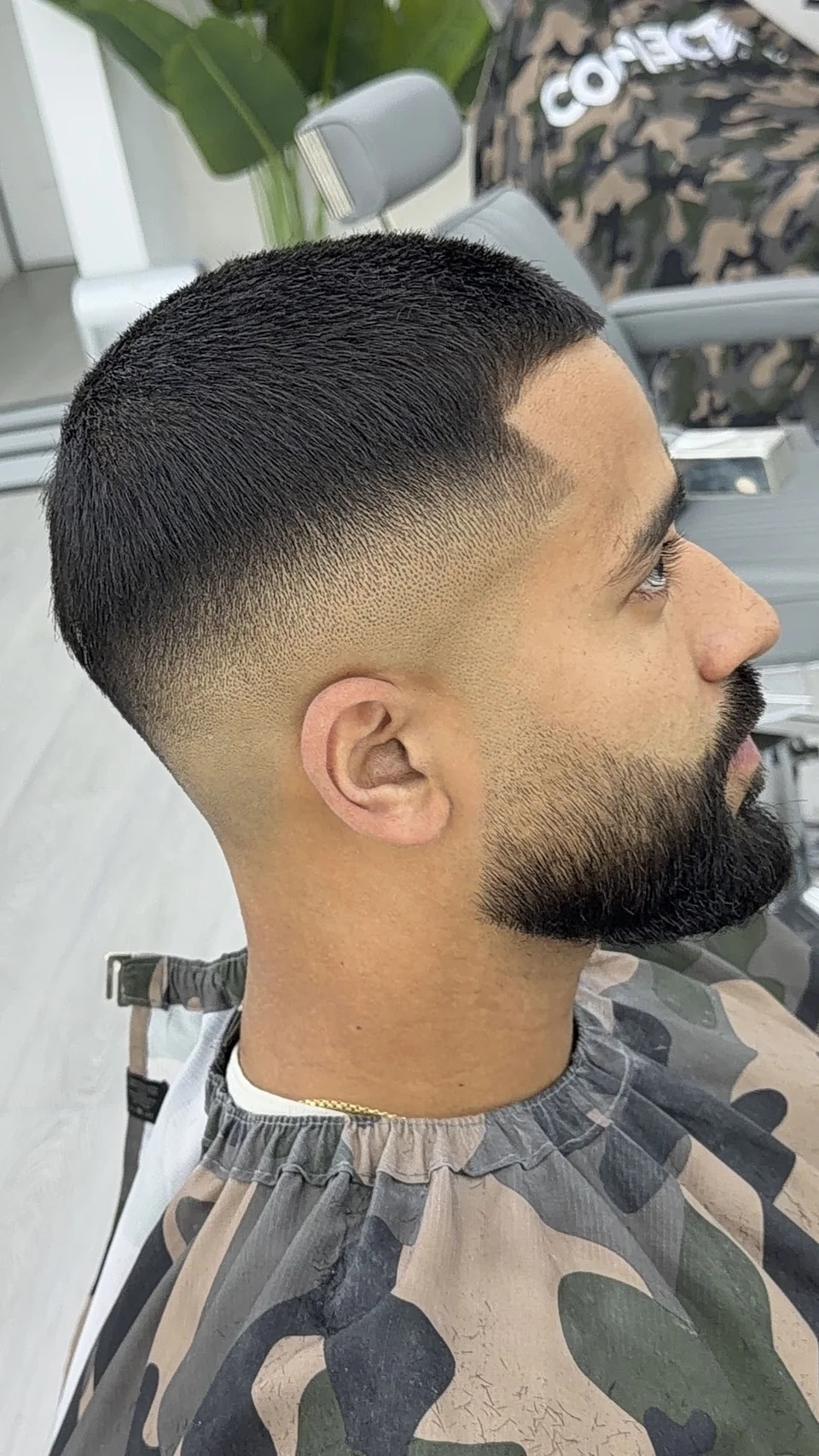 A close fade with a neatly shaped full beard